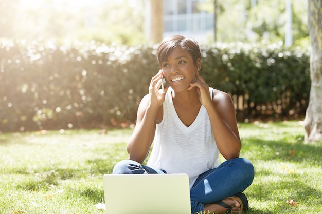 Young woman with short hair sitting in park