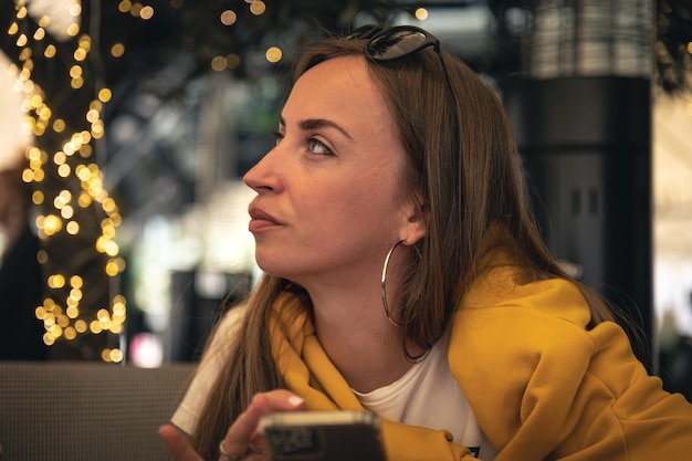 A young woman with a smartphone in her hands on a blurred background