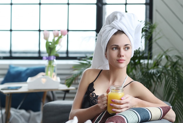 Free photo young woman with towel on her head and orange juice