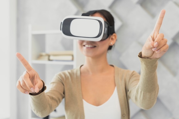 Young woman with virtual headset pointing