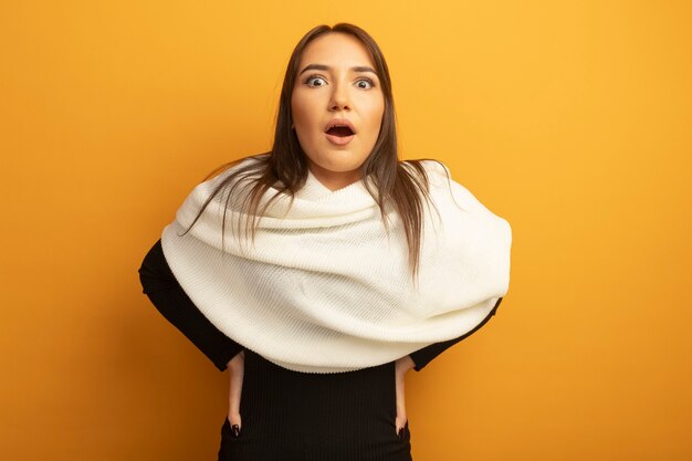 Young woman with white scarf amazed and surprised 