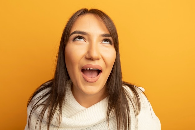 Young woman with white scarf looking up happy adn cheerful 