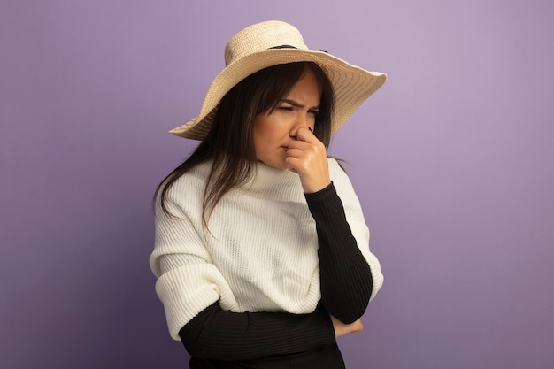 Free photo young woman with white scarf and summer hat looking aside confused