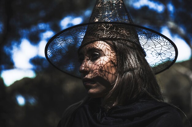 Young woman in wizard costume with half turned head looking away