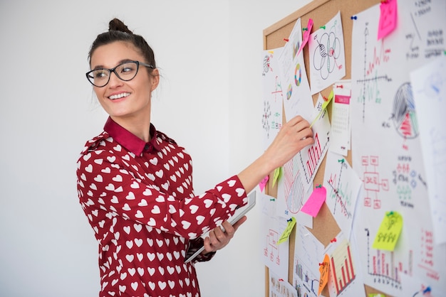 Young woman working on announcement board at office