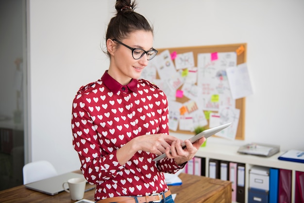 Free Photo young woman working on digital tablet at office