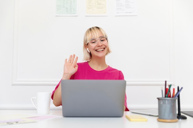 Free photo young woman working from home on her laptop