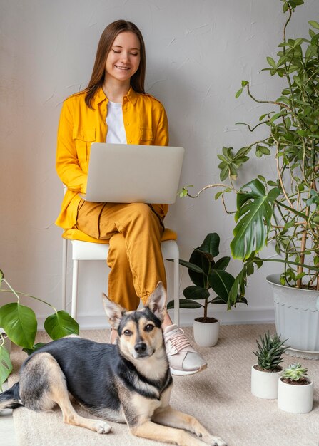 Young woman working in her home garden next to her dog