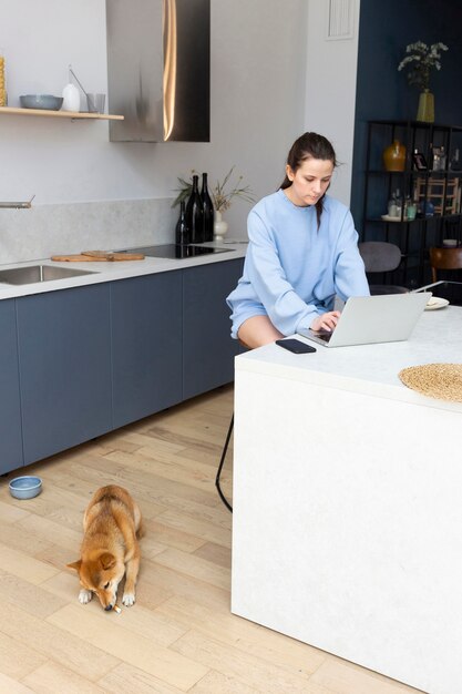 Young woman working on her laptop next to her dog