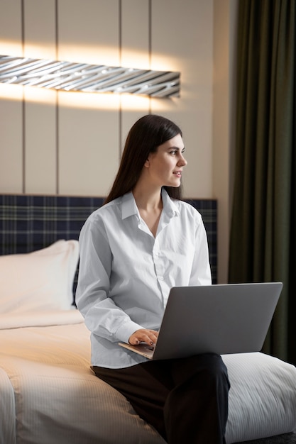 Young woman working on her laptop in a hotel room