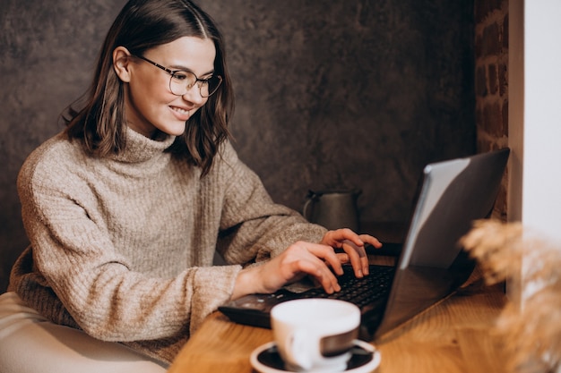 Young woman working on laptop in a cafe