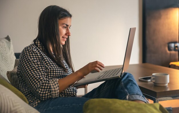 A young woman working on a laptop at home