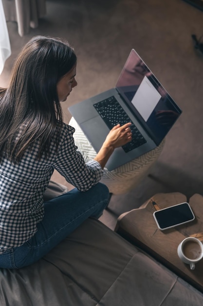 A young woman working on a laptop at home