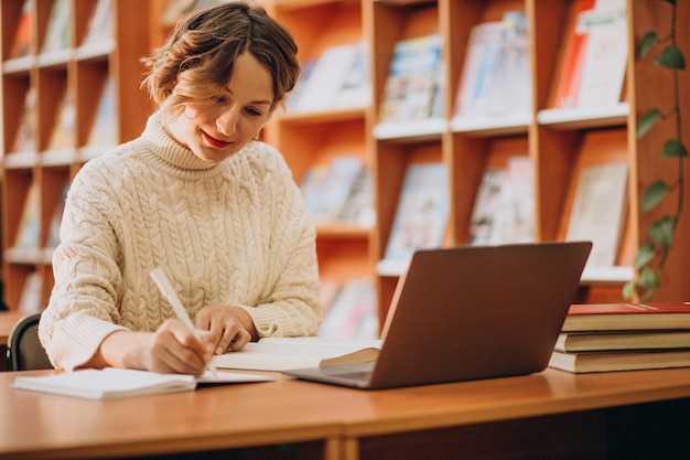 Free photo young woman working on laptop in a library