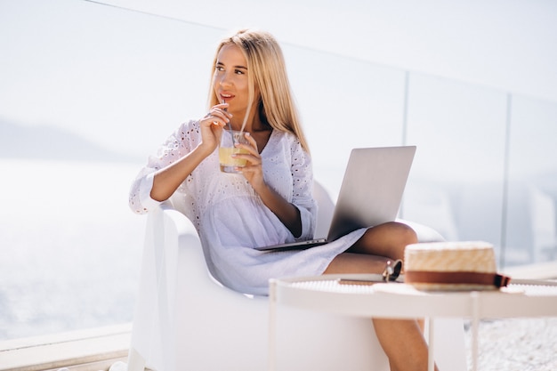 Young woman working on laptop on a vacation