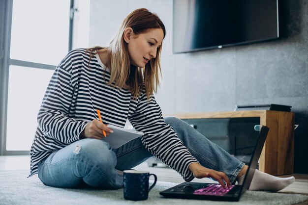 Young woman working and studying on her laptop from home