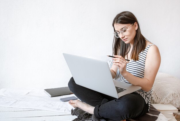 A young woman works remotely at a computer at home. Freelancer and work on the Internet.