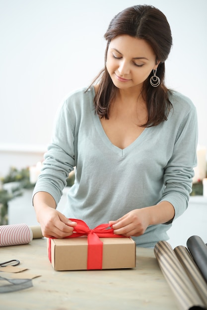 Free photo young woman wrapping christmas presents