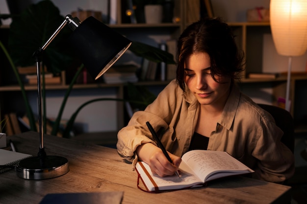 Free photo young woman writing in her journal