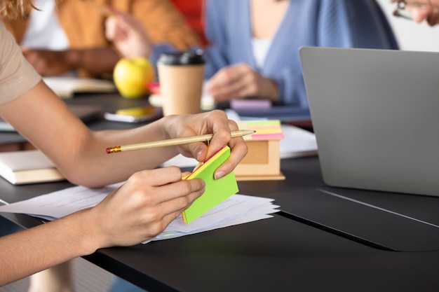 Free photo young woman writing information on sticky notes during study session