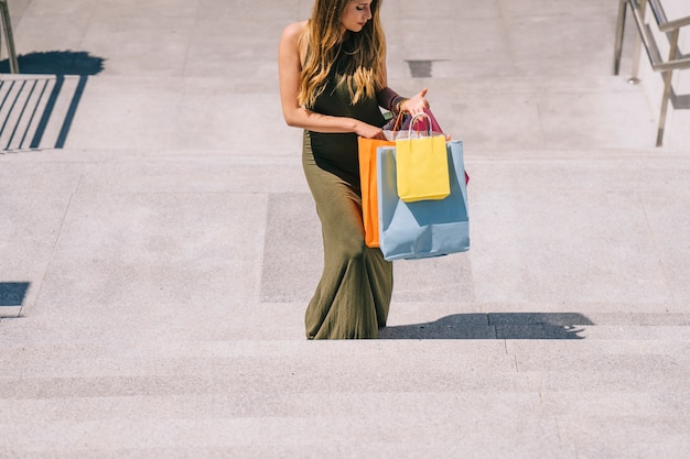 Free photo young womangoing upstairs after shopping