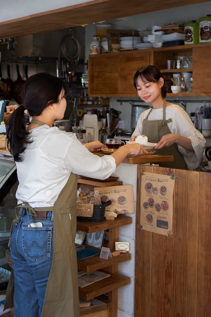 Free photo young women arranging their cake shop