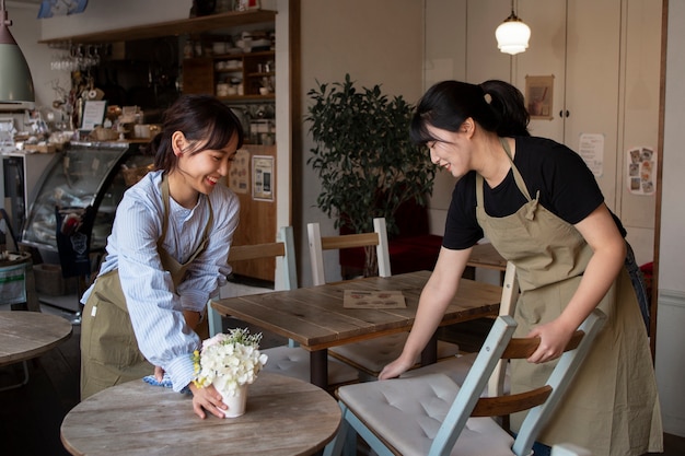 Free photo young women arranging their cake shop