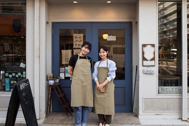 Free photo young women arranging their cake shop