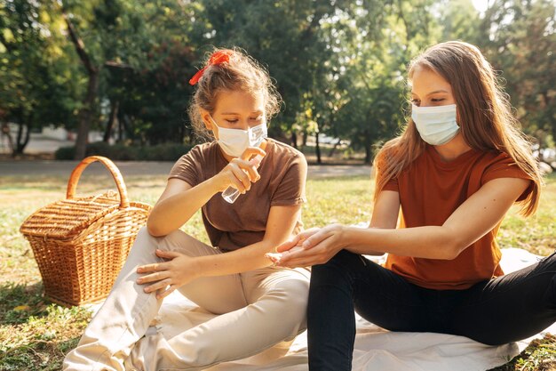 Young women disinfecting before having a picnic