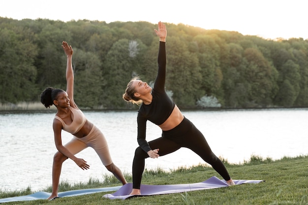 Young women doing fitness outdoors together