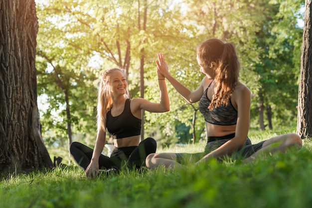 Free photo young women doing yoga in the park