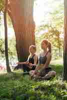 Free photo young women doing yoga in the park