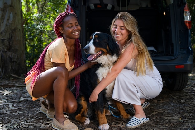 Free photo young women having fun with  dog at the beach