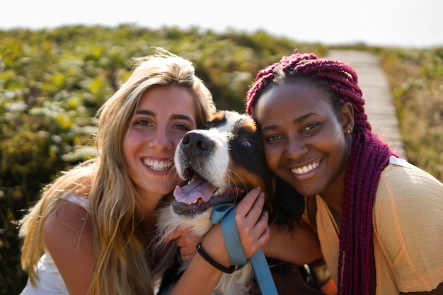 Free photo young women having fun with  dog at the beach