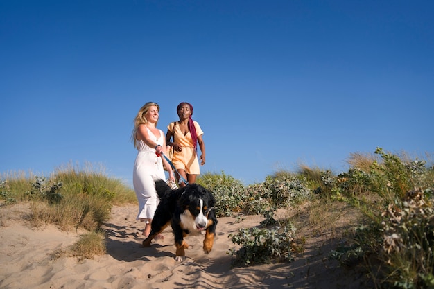 Young women having fun with  dog at the beach