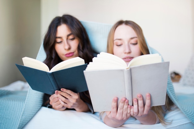 Young women reading in bed