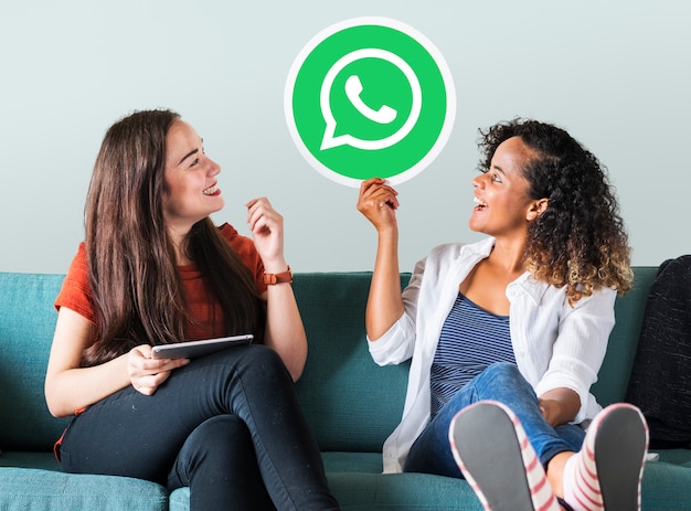 Free photo young women showing a whatsapp messenger icon