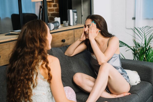 Young women sitting on sofa at home