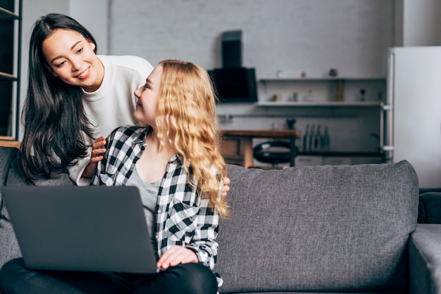 Young women talking and surfing on laptop