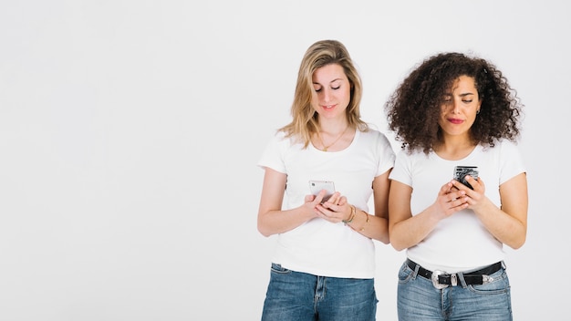 Young women using smartphones together