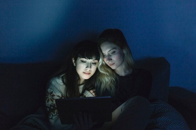 Young women watching tablet in dark