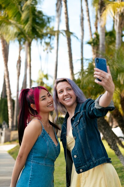 Young women with dyed hair near lake