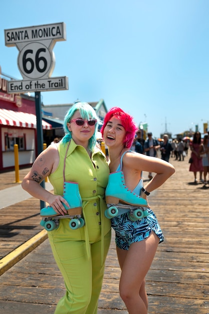 Free photo young women with dyed hair near seaside