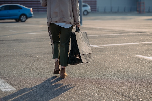 Young women with shopping bags walking on street.