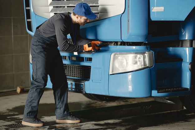 A young worker checks the wheel. Truck malfunction. Service work.