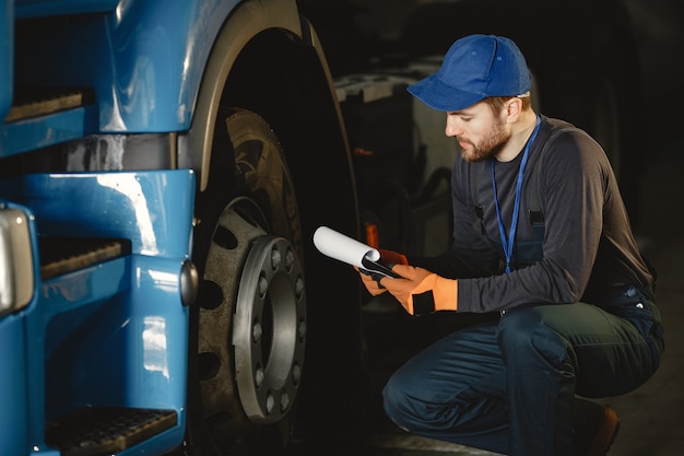 Free photo a young worker checks wheel. truck malfunction. service work.