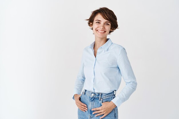 Young working woman in office clothing smiling and looking at camera standing on white background Professional women concept