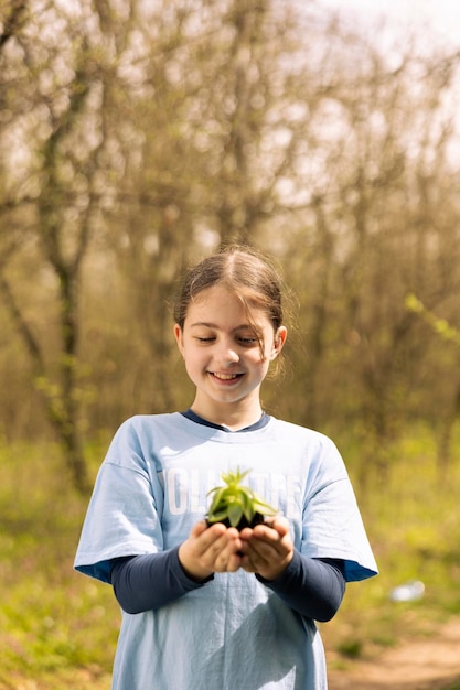 Free photo youngster fighting for forest ecosystem by holding a green seedling with soil