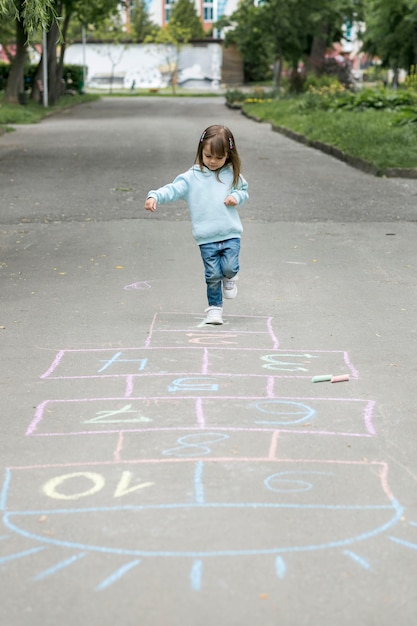 Youngster outdoors playing hopscotch