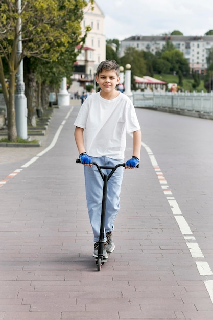 Youngster outdoors on scooter front view